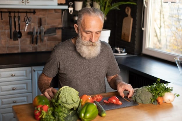 A senior man in his kitchen using a vegetable chopper to prepare a salad. He is smiling and seems to be enjoying the process. The kitchen is organized and well-lit, indicating an accessible cooking environment.