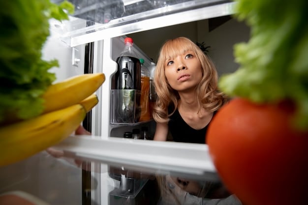 A person looking into their refrigerator, filled with various fruits, vegetables, and condiments, planning their meals around expiring items.