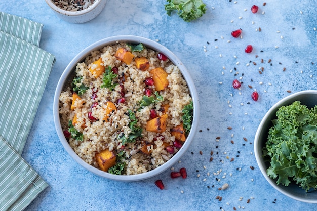 A colorful vegan Buddha bowl filled with quinoa, roasted vegetables (broccoli, bell peppers, sweet potatoes), chickpeas, avocado slices, and a tahini dressing drizzled on top. The bowl is set against a bright, natural background with vibrant ingredients that highlight the diversity and nutritional richness of a vegan diet.