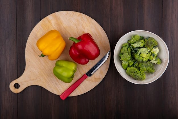 A close-up shot of various fresh vegetables (broccoli, bell peppers, onions) being chopped and prepared on a wooden cutting board. A chef's knife is in the frame, and the vegetables are vibrant and colorful.