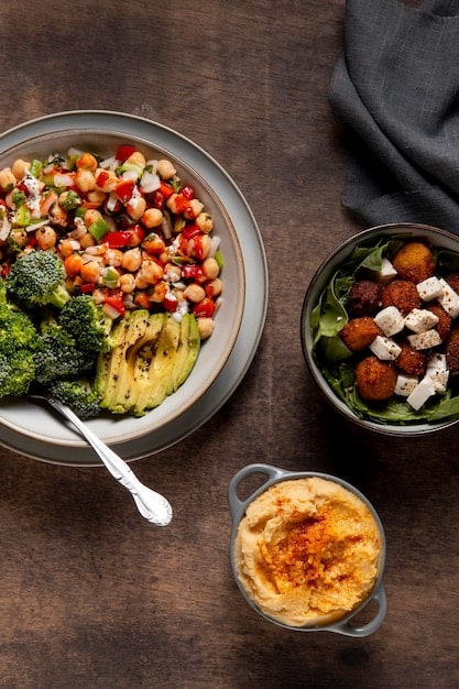 Overhead shot of a table set with several healthy comfort food dishes, including a bowl of low-sodium mac and cheese, a plate of shepherd's pie with fresh vegetables, and a bowl of homemade soup with herbs.