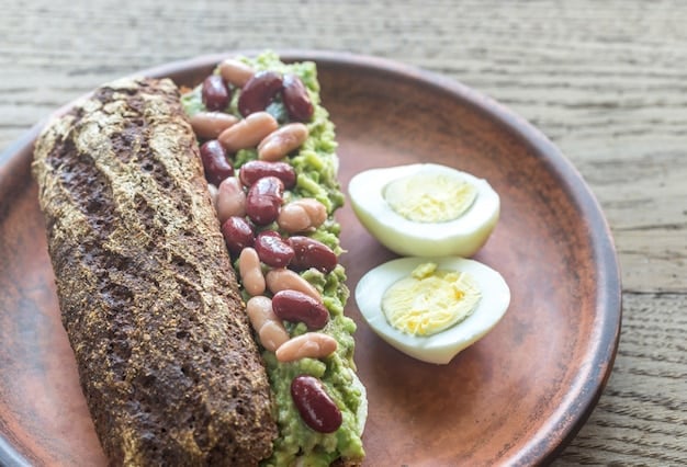 A cross-sectional view of a breakfast burrito, revealing layers of scrambled eggs, black beans, salsa, cheese, and avocado all wrapped in a warm tortilla, with a bright, colorful filling visible.
