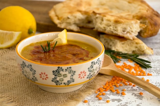 A close-up view of a bowl of lentil soup, garnished with fresh herbs and a drizzle of olive oil. The soup is hearty and steaming, showcasing its comforting and protein-rich nature.