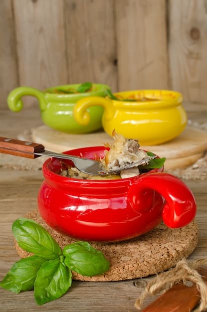 A steaming bowl of colorful cabbage detox soup, with visible chunks of cabbage, tomatoes, and bell peppers. The soup is garnished with fresh parsley and a slice of lemon.