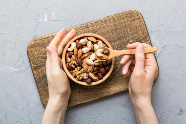 A close-up shot of a hand grabbing a handful of mixed nuts and seeds, including almonds, walnuts, pumpkin seeds, and sunflower seeds. The focus is on the variety and texture of the nuts and seeds, emphasizing their role as a healthy pre-workout snack.