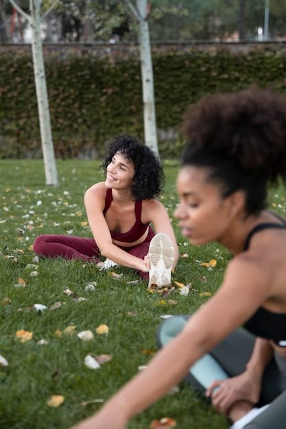 A diverse group of athletes stretching lightly after a training session on a sunny outdoor field, emphasizing camaraderie and varied recovery techniques.