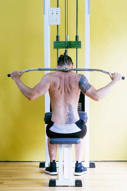 A close-up shot of a person's back muscles during a seated cable row. Focus on the contraction of the lats and rhomboids as they pull the cable towards their abdomen. Ensure proper posture with a straight back and engaged core.