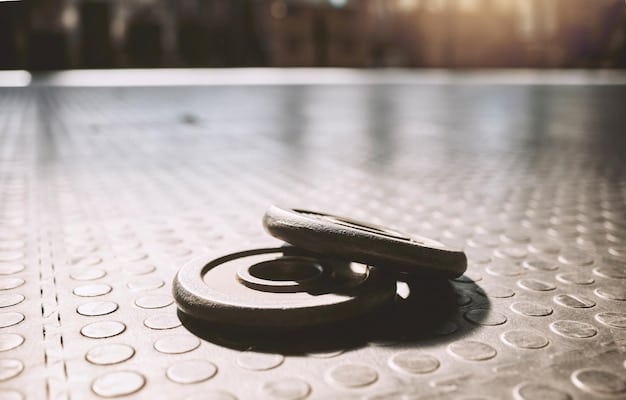 A close-up of a kettlebell resting on a gym floor, highlighting its textured handle and rounded shape, with fitness equipment blurred in the background.