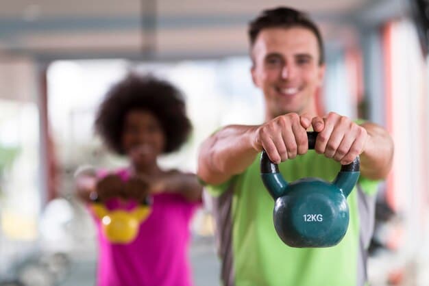 A fitness instructor demonstrating a kettlebell exercise in a gym setting, providing guidance and support to a participant.