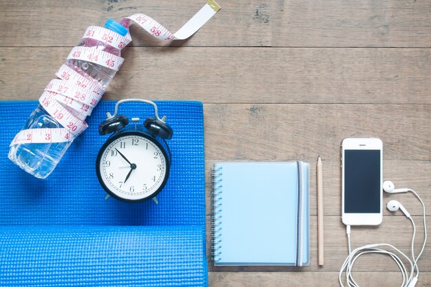 A timer set to 20 minutes on a fitness app, with workout clothes and a water bottle nearby.