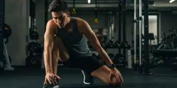 Athlete stretching after intense workout, focusing on muscle recovery